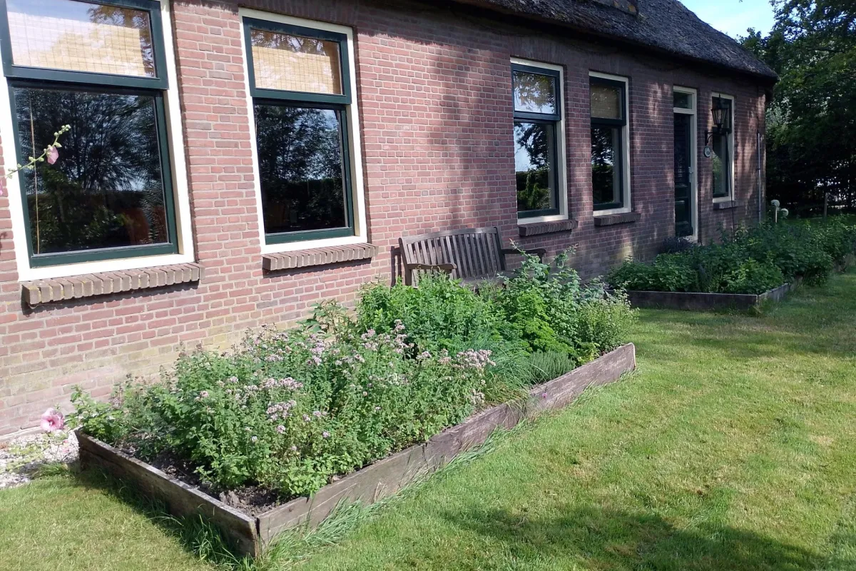 Vooraanzicht van de vakantiewoning met ruime tuin en kruidentuin
