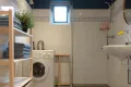 Badkamer met douche, toilet en wasmachine